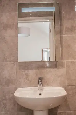 a bathroom with a white sink and a mirror at Keld Green House in Seascale