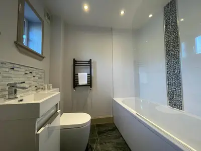 a bathroom with a tub and a toilet and a sink at Apartments No. 19 in Portpatrick