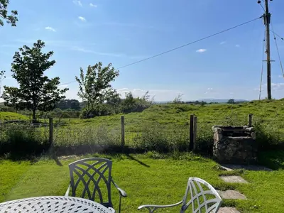 two chairs and a table in a field at Barcloy Honey House in Kirkcudbright