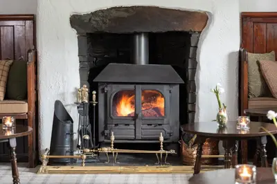 a fireplace in a living room with a stove at The King's Head in Thirlmere