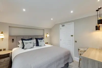 a bedroom with a large white bed and a desk at The Borrowdale Hotel in Keswick