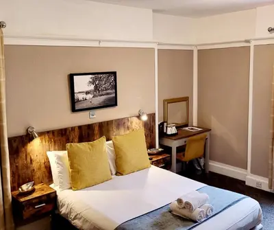 a hotel room with a bed and a desk at The Market Inn Hotel in Castle Douglas