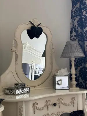 a mirror on top of a dresser with a lamp at Dale Head Hall Lakeside Hotel in Keswick