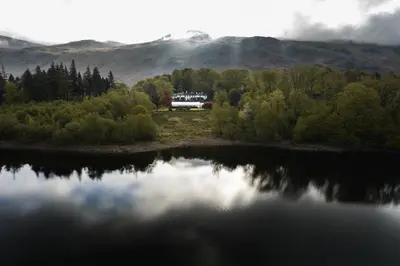 a house is sitting on the shore of a lake at Dale Head Hall Lakeside Hotel in Keswick