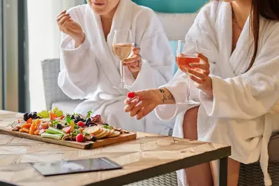 two women sitting at a table with glasses of wine at Comis Hotel & Golf Resort in Douglas