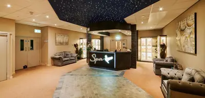 a salon with a waiting room with chairs and a bar at Comis Hotel & Golf Resort in Douglas