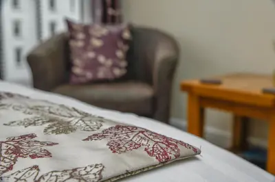 a bed with a chair and a pillow on it at West View in Keswick