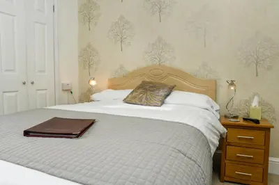 a bedroom with a bed with a pillow and a night stand at West View in Keswick