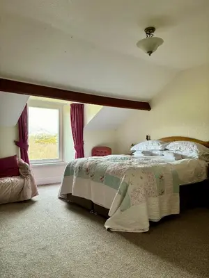 a bedroom with a large bed and a window at Forest How Guest House in Eskdale