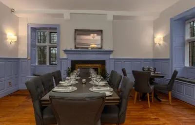 a dining room with a table and chairs and a fireplace at Sella Park Country House Hotel in Seascale