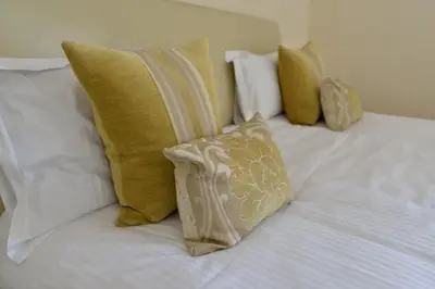 a group of pillows on a white bed at Sella Park Country House Hotel in Seascale