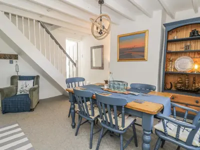 a dining room with a blue table and chairs at Marsh Villa in Skinburness