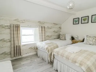 a bedroom with two beds and a window at Marsh Villa in Skinburness