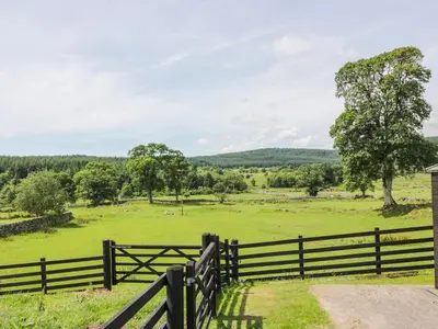 a fence with a view of a field at Bracken Holiday Cottage in Dalbeattie