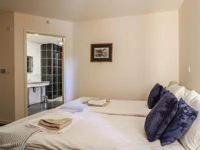 a bedroom with two beds with towels on them at Esthers Barn in Cockermouth