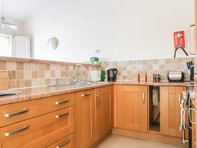 a kitchen with wooden cabinets and a sink at Esthers Barn in Cockermouth