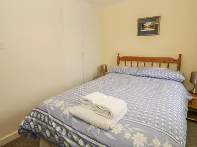 a bedroom with a bed with towels on it at 2 Park Nook Close in Waberthwaite