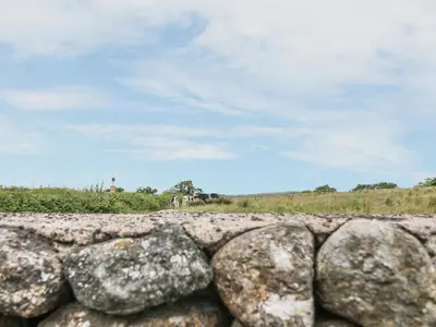 a stone wall with rocks in front of a field at 2 Park Nook Close in Waberthwaite