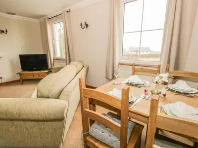a living room with a table and a couch at 1 Park Nook Close in Waberthwaite