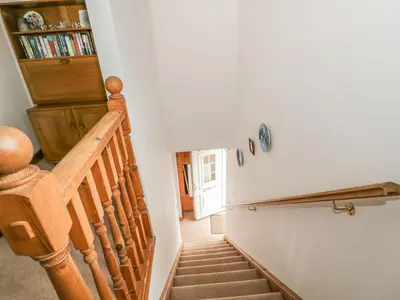 a staircase in a home with a wooden stair case at 1 Park Nook Close in Waberthwaite