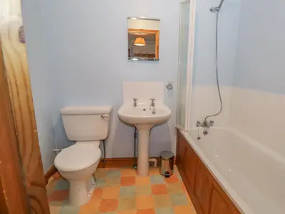 a bathroom with a toilet and a sink and a tub at 1 Park Nook Close in Waberthwaite