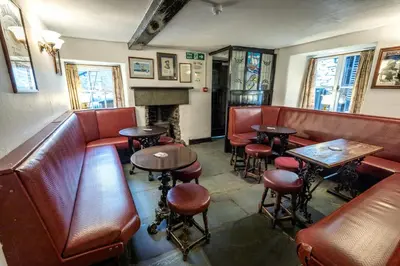 a restaurant with tables and chairs and a fireplace at The Britannia Inn in Elterwater