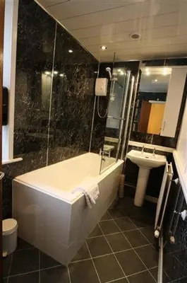 a bathroom with a shower and a tub and a sink at Strands Hotel/Screes Inn & Micro Brewery in Nether Wasdale