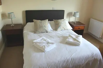 a bedroom with a white bed with two towels on it at Embleton Spa Hotel & Apartments in Embleton