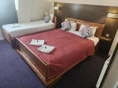 two beds in a hotel room with two plates on them at The Queensberry Hotel in Dumfries