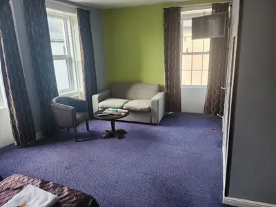 a living room with a couch and a chair at The Queensberry Hotel in Dumfries