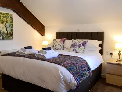 a bedroom with a large bed with towels on it at Farmhouse Cottage - Uk1285 in Westward