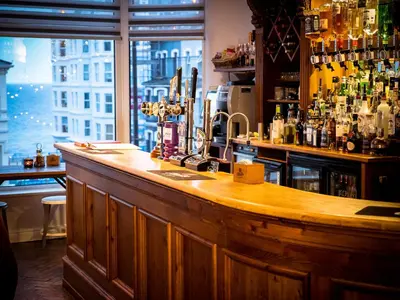 a bar with a wooden counter and a window at Rosslyn in Douglas