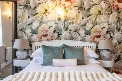 a bedroom with a bed with a floral wallpaper at Georgian House Hotel in Whitehaven
