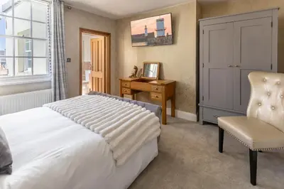 a bedroom with a bed and a desk and a chair at Georgian House Hotel in Whitehaven