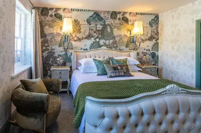 a bedroom with a bed with a green comforter at Georgian House Hotel in Whitehaven
