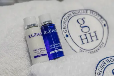 two bottles of sunscreen sitting on top of white towels at Georgian House Hotel in Whitehaven