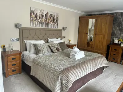 a bedroom with a large bed and a wooden cabinet at Black Bull Inn, Moffat in Moffat