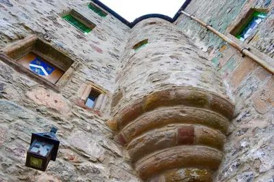a large stone building with a clock on it at The Lady Maxwell Room at Buittle Castle in Dalbeattie