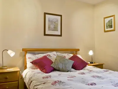 a bedroom with a bed with two pillows on it at Bobbin Cottage in Keswick