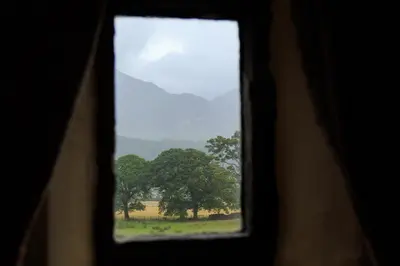 a view of a window with a tree in a field at Kirkstile Inn in Loweswater