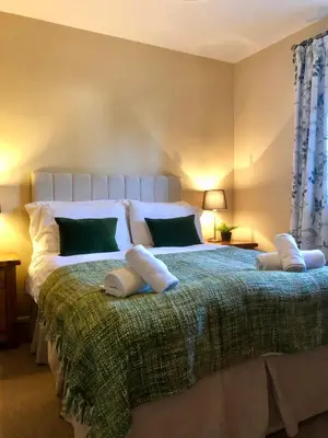 a bedroom with a large bed with pillows on it at Kirkstile Inn in Loweswater