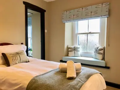 a bedroom with a bed with a mirror and a window at Kirkstile Inn in Loweswater