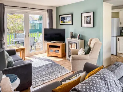 a living room with a couch and a television at Briargarth in Keswick