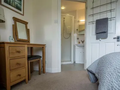 a bedroom with a dresser and a mirror and a sink at Briargarth in Keswick