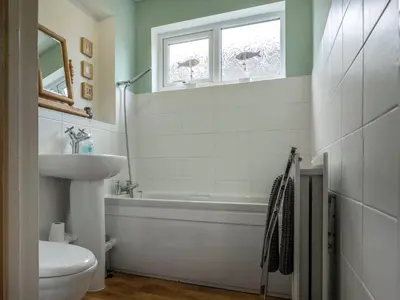 a bathroom with a tub and a sink and a toilet at Briargarth in Keswick
