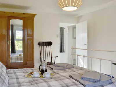 a bedroom with a bed with a plate of food on it at Apple Tree Cottage in Bassenthwaite