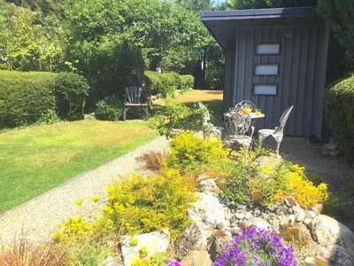 a garden with a table and chairs and flowers at Apple Tree Cottage in Bassenthwaite