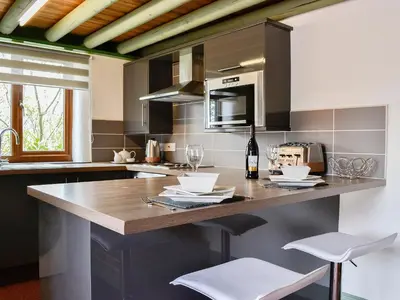 a kitchen with a counter with two chairs and a sink at Darci's Lodge - Uk1297 in Threlkeld