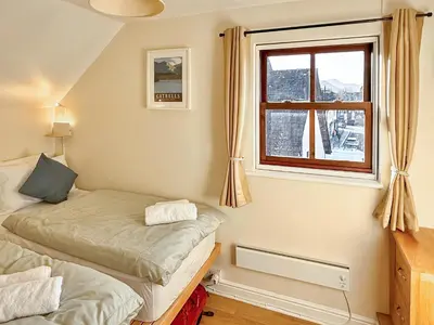 two twin beds in a room with a window at Hindscarth in Keswick