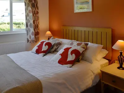 a bedroom with a bed with red and white pillows at Rotherwood in Portinscale